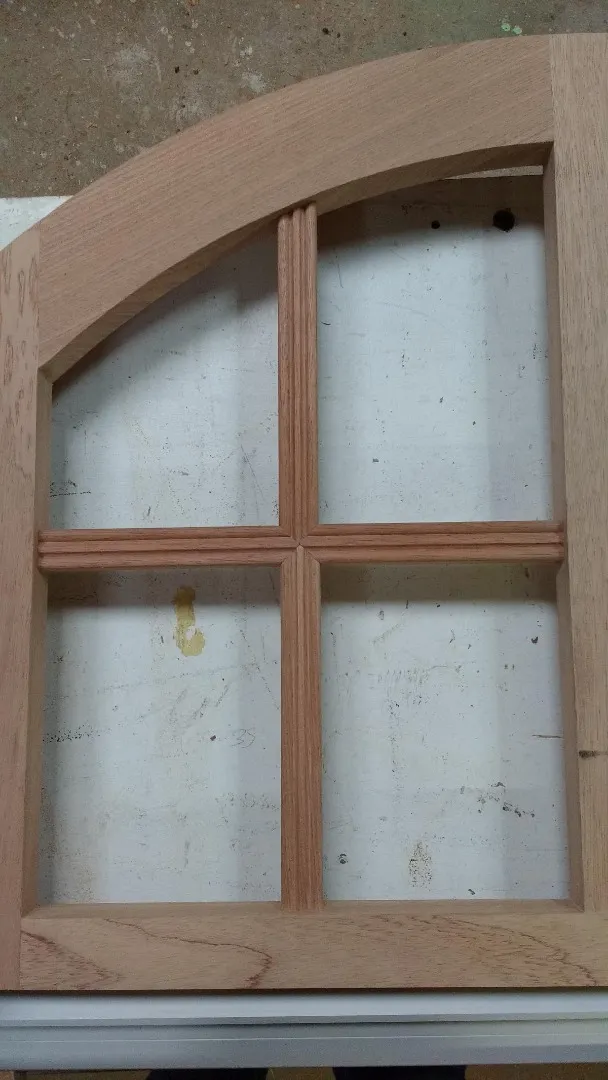 Détail des petits bois moulurés d’une imposte cintrée