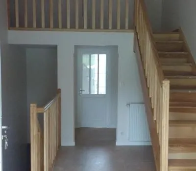 Escalier en bois et garde-corps entourant une trémie vus depuis la pièce