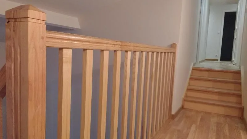 Garde-corps en bois à barreaux verticaux installé autour d’un palier