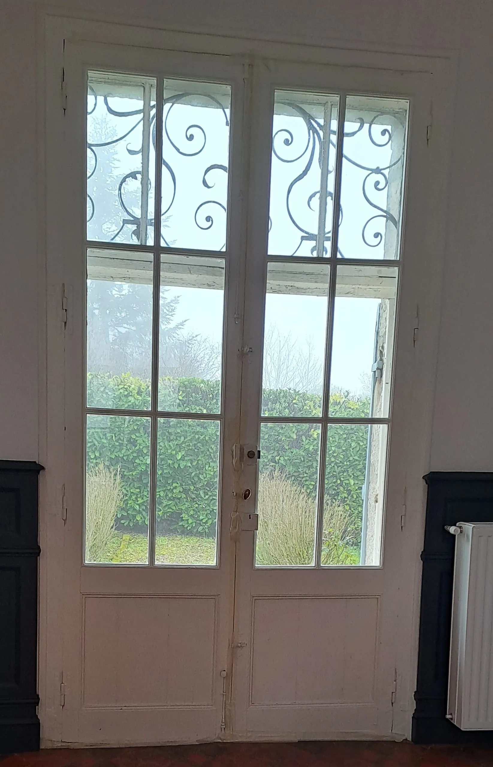 Porte vitrée blanche à petits carreaux vue depuis un intérieur